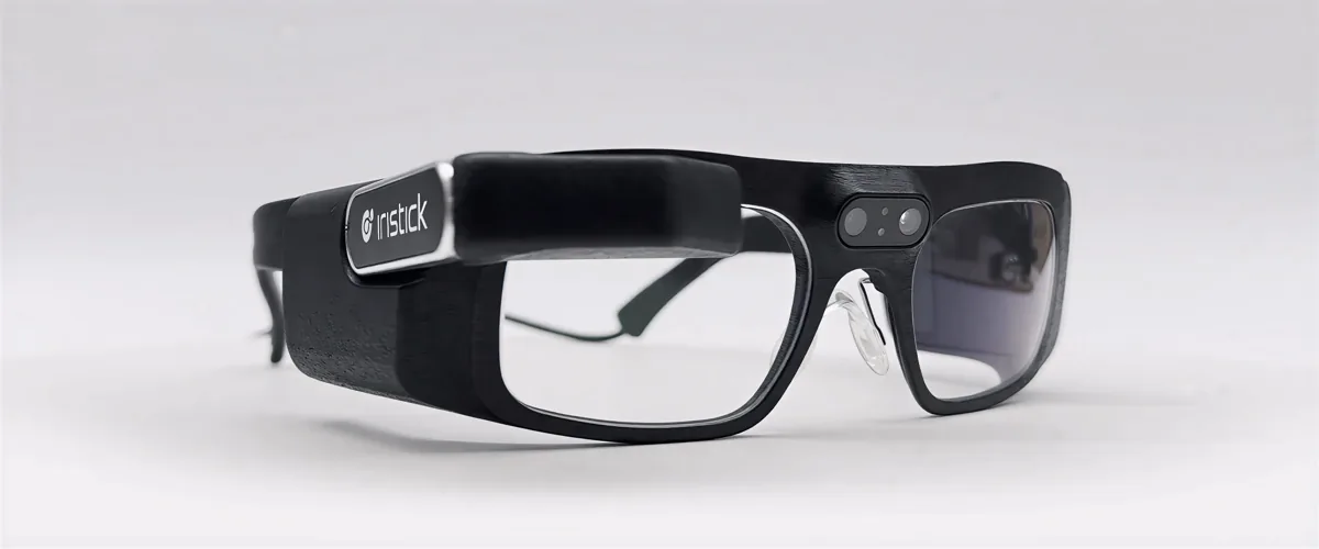 Black safety-glasses-form smart glasses with a compact display and camera module on the right temple